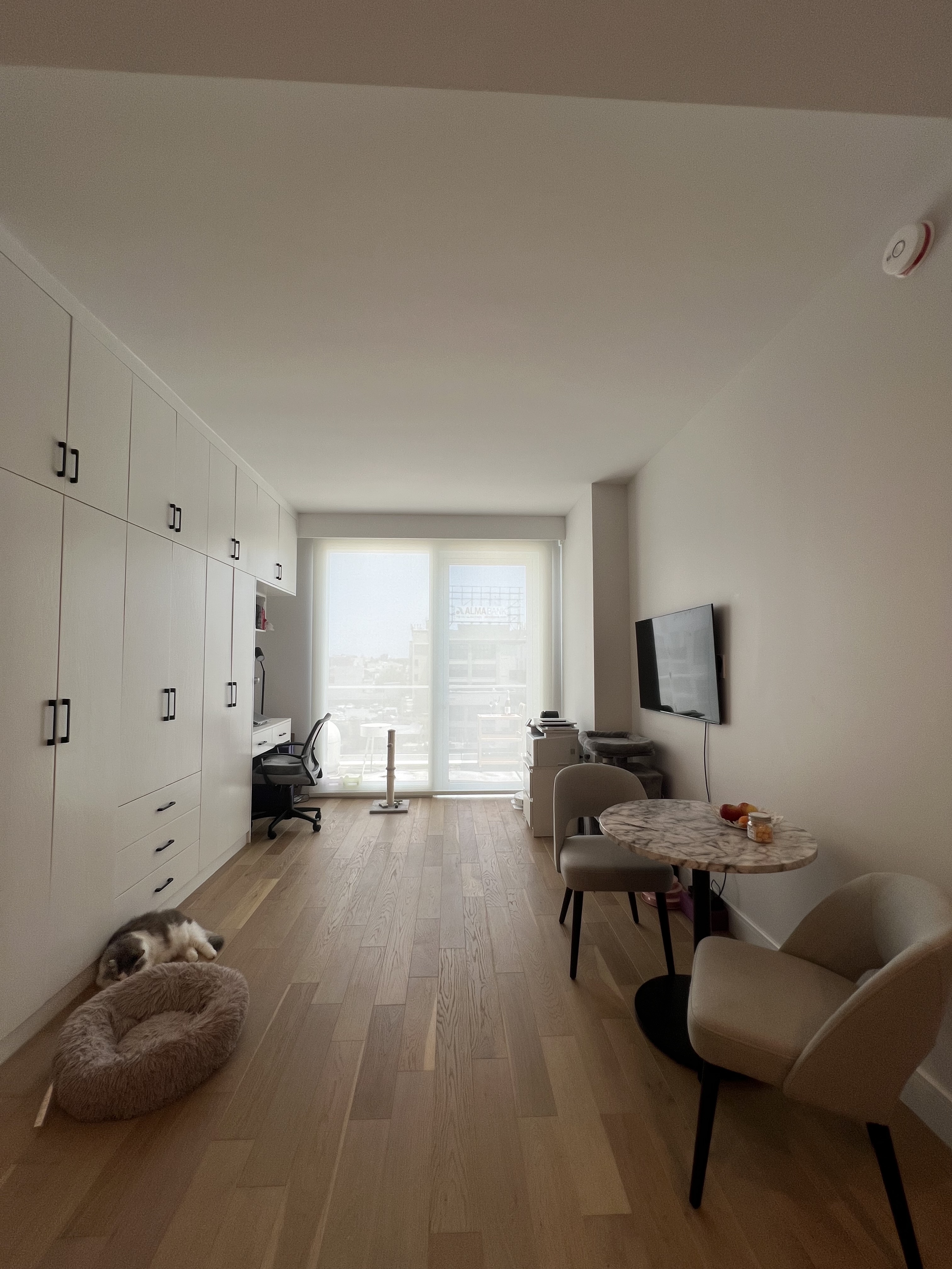 37-34 33rd Street, Unit 7H Queens, NY 11101 - Photo 10 of 18 a living room with furniture and a flat screen tv