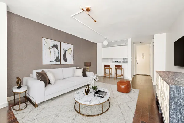 a living room with furniture and a dining table with kitchen view