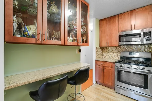 a kitchen with granite countertop wooden cabinets and a stove top oven