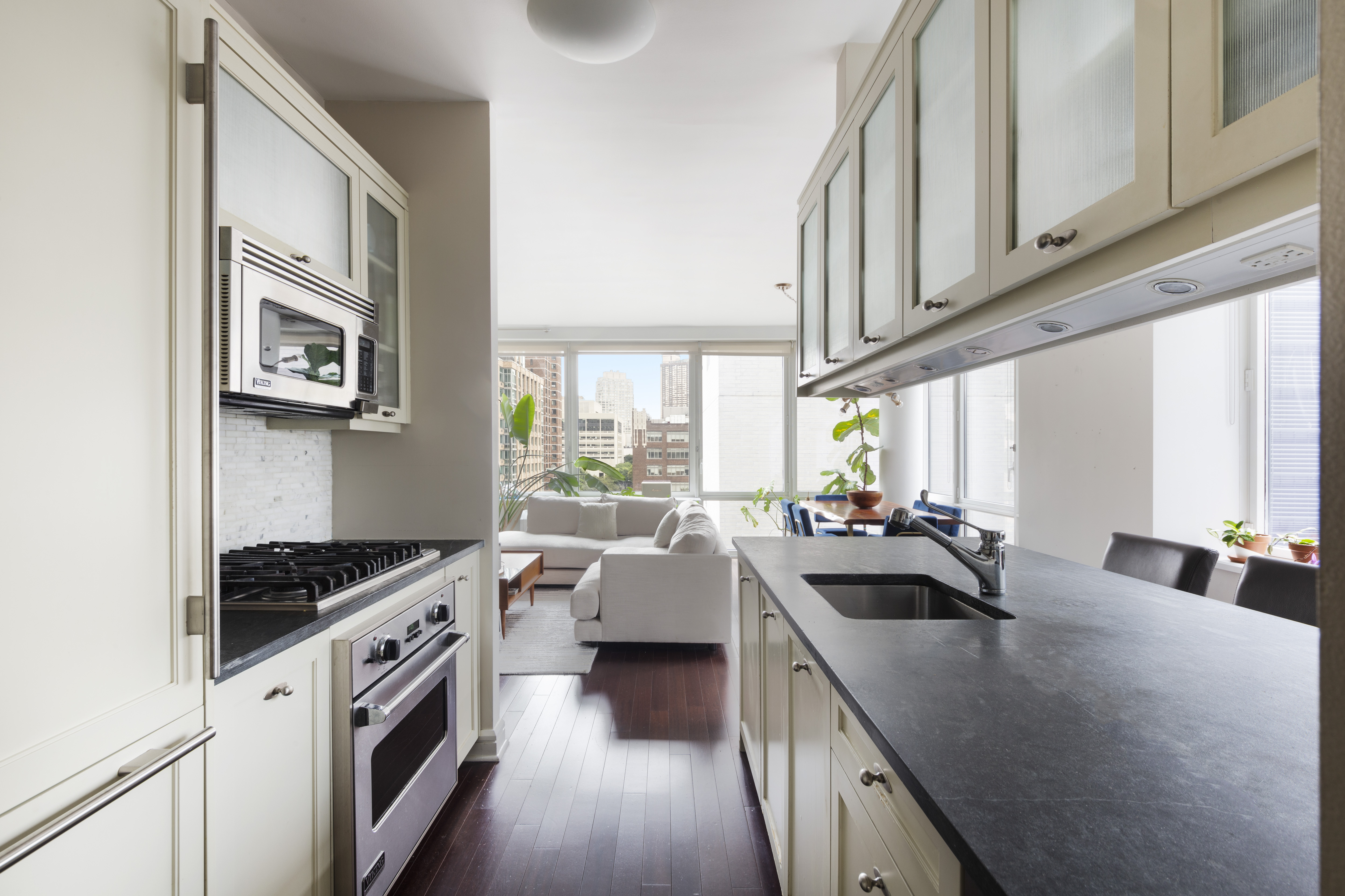 80 Riverside Boulevard, Unit 9E Manhattan, NY 10069 - Photo 5 of 14 a kitchen that has a sink and a stove with wooden floor