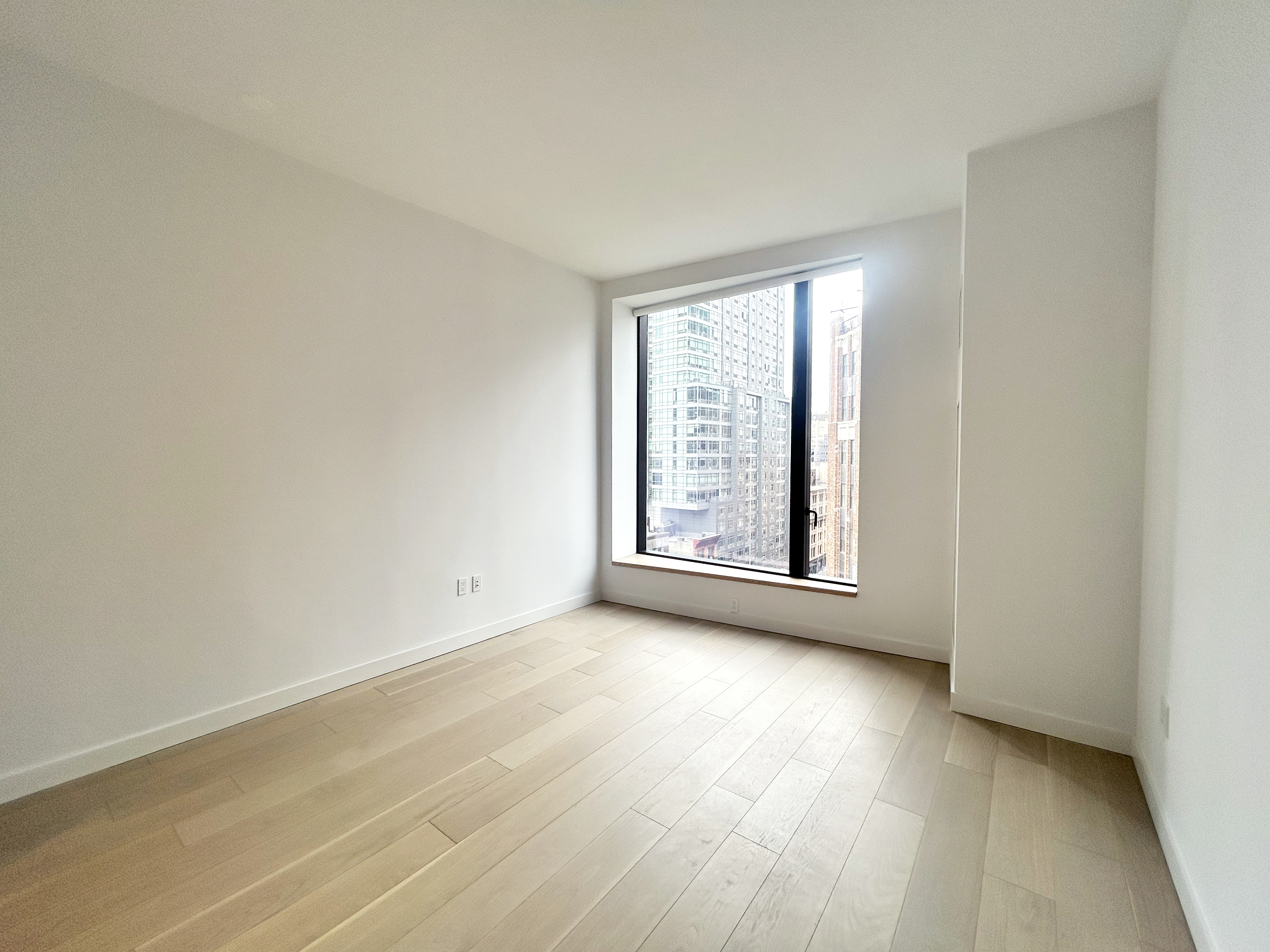 11 Hoyt Street, Unit 10M Brooklyn, NY 11201 - Photo 2 of 24 an empty room with wooden floor and windows