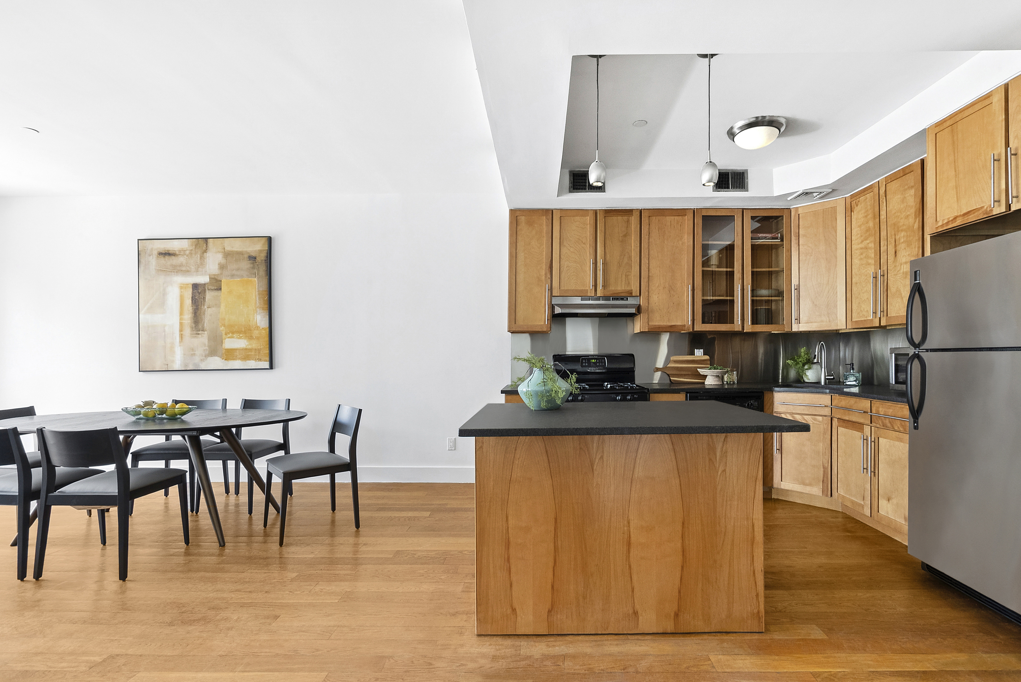 201 Spencer Street, Unit 3A Brooklyn, NY 11205 - Photo 2 of 11 a kitchen with stainless steel appliances granite countertop a stove a refrigerator a dining table and chairs