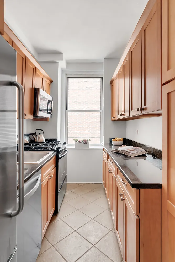 a kitchen with stainless steel appliances granite countertop a stove a sink and a refrigerator