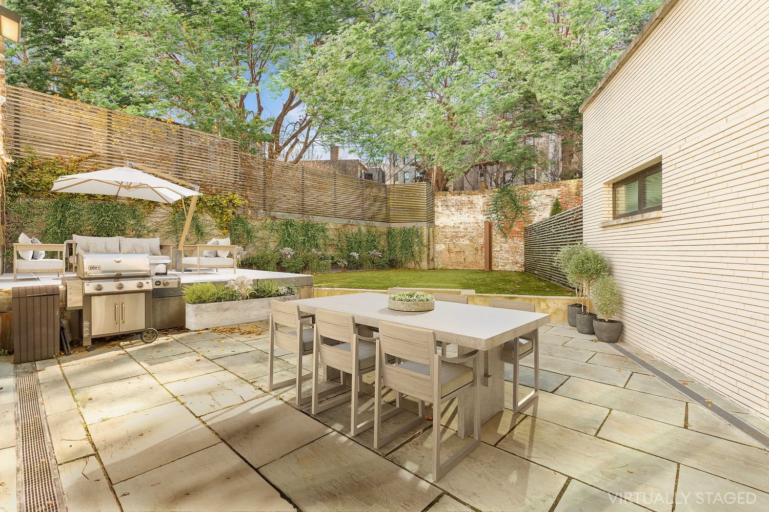 a view of a patio with table and chairs under an umbrella