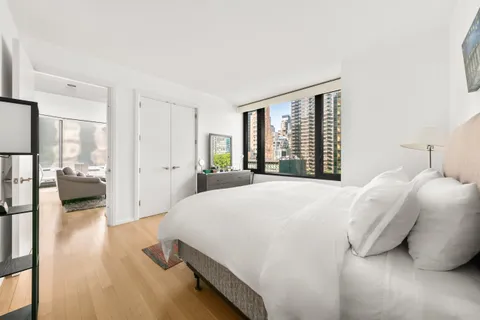 a bedroom with a bed and a large window