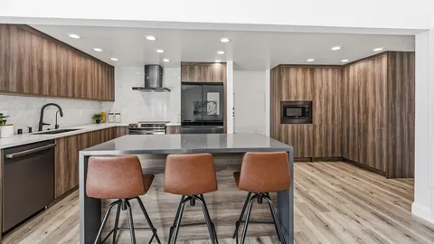 a kitchen with kitchen island granite countertop wooden cabinets and a refrigerator