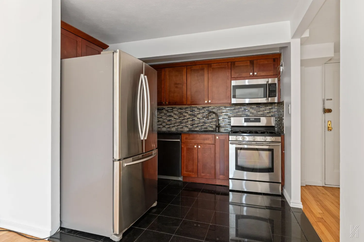 a kitchen with stainless steel appliances granite countertop a refrigerator and a sink