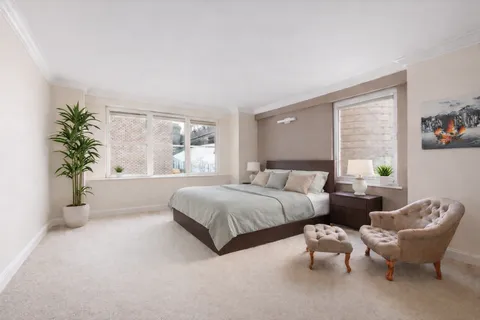 a spacious bedroom with two beds and potted plant