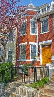 front view of a brick house with a yard