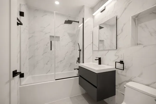 a bathroom with a sink vanity toilet and shower
