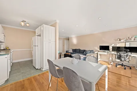 a living room with furniture a flat screen tv and a refrigerator