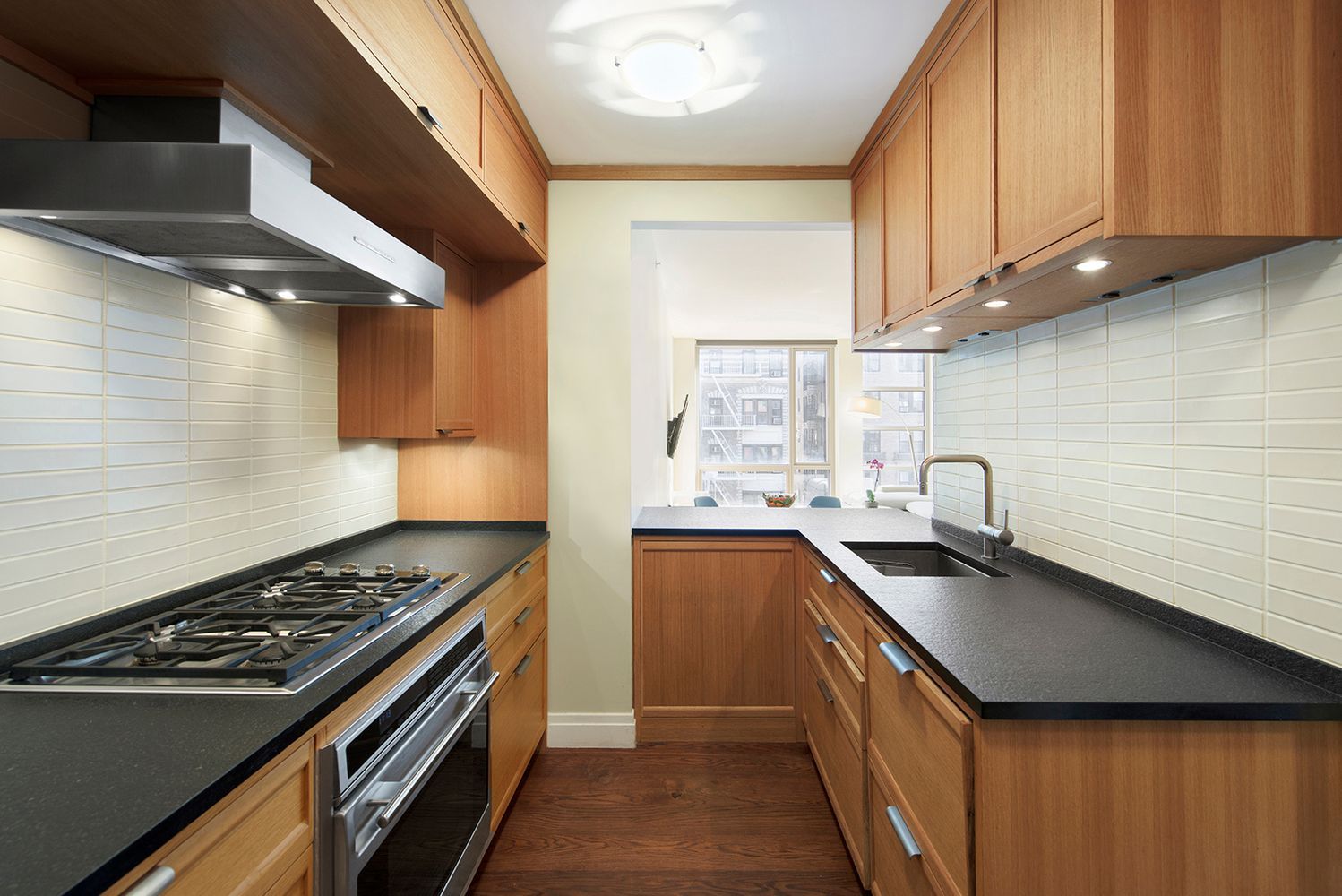 177 9th Avenue, Unit 4F Manhattan, NY 10011 - Photo 2 of 13 a kitchen with a sink a stove cabinets and a window