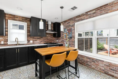 a kitchen with a table chairs sink and cabinets
