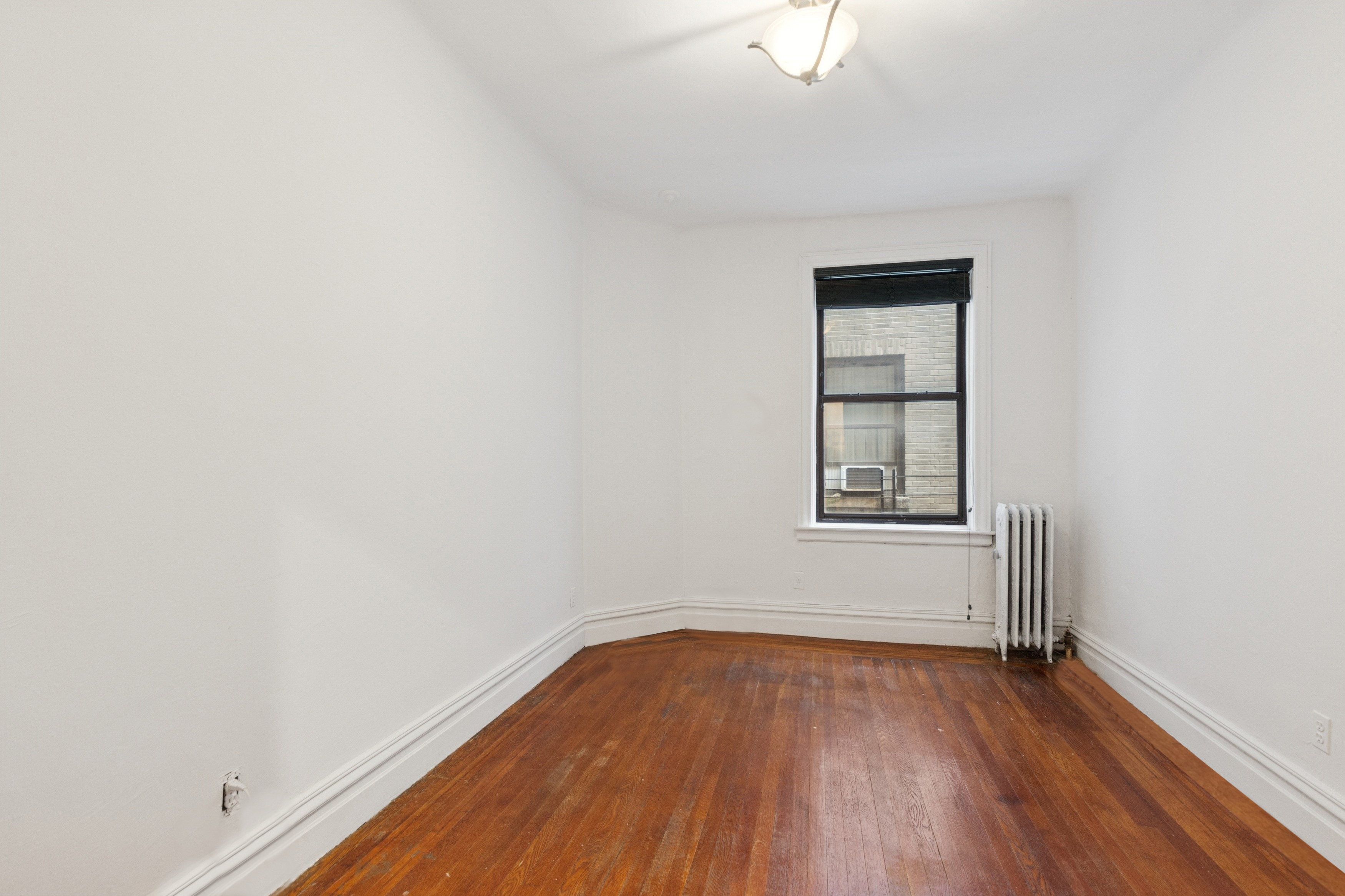 804 West 180th Street, Unit 41 Manhattan, NY 10033 - Photo 13 of 23 an empty room with wooden floor and windows
