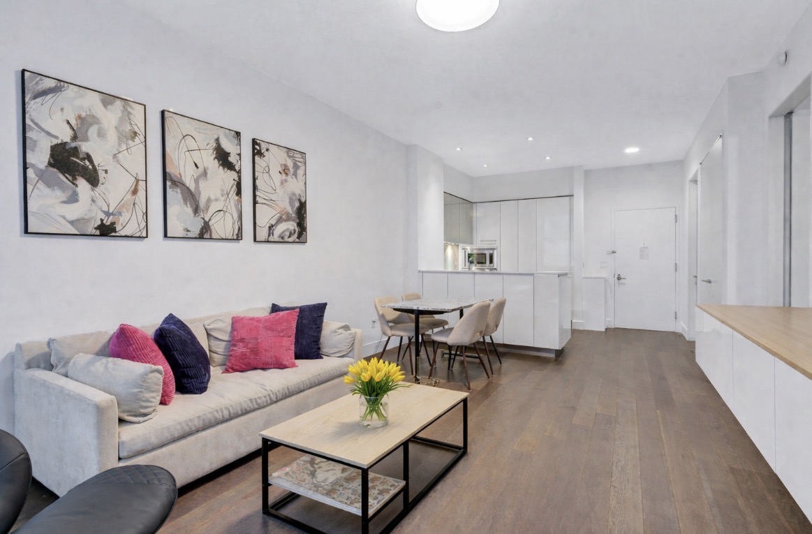 25 Broad Street, Unit 11K Manhattan, NY 10004 - Photo 2 of 16 a living room with furniture and kitchen view