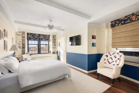 a bedroom with a bed a dresser next to a window