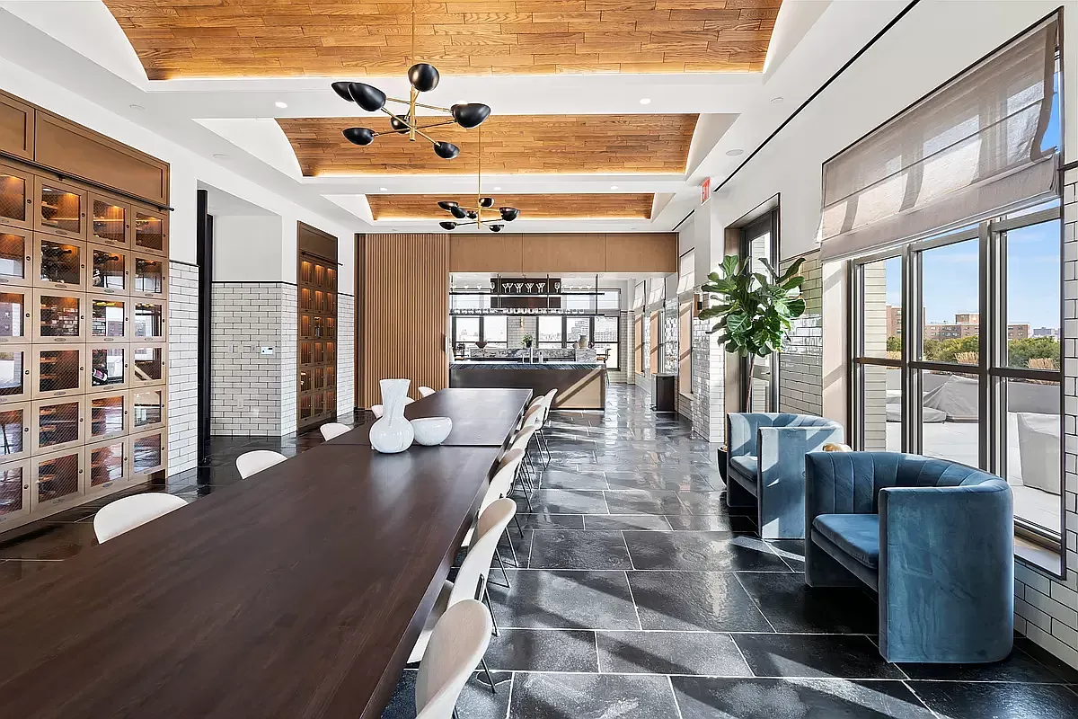 a living room with furniture potted plant floor to ceiling windows and a flat screen tv