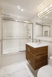a bathroom with a double vanity sink a mirror and a bathtub