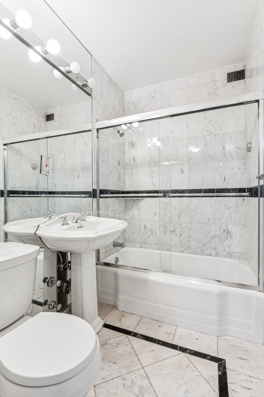 116 Central Park South, Unit 7C Manhattan, NY 10019 - Photo 5 of 6 a bathroom with a sink a mirror and a toilet