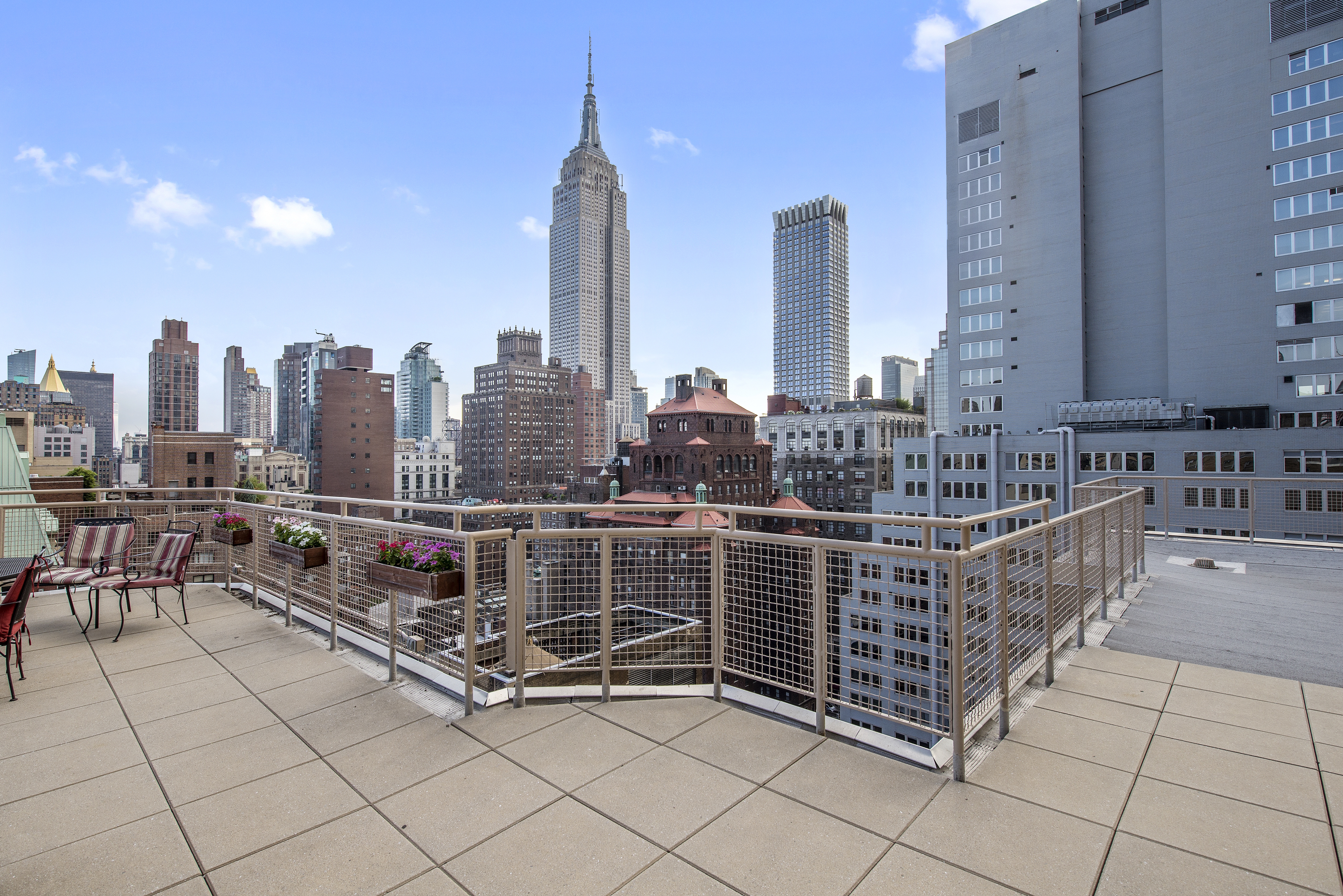 80 Park Avenue, Unit 9L Manhattan, NY 10016 - Photo 9 of 10 a view of roof deck with dining table and chairs