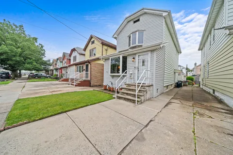 a view of a white house with a yard and plants