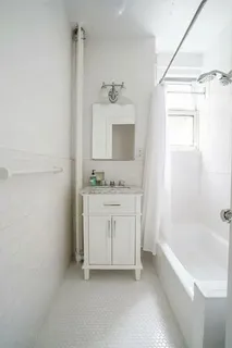 a bathroom with a shower sink and a mirror