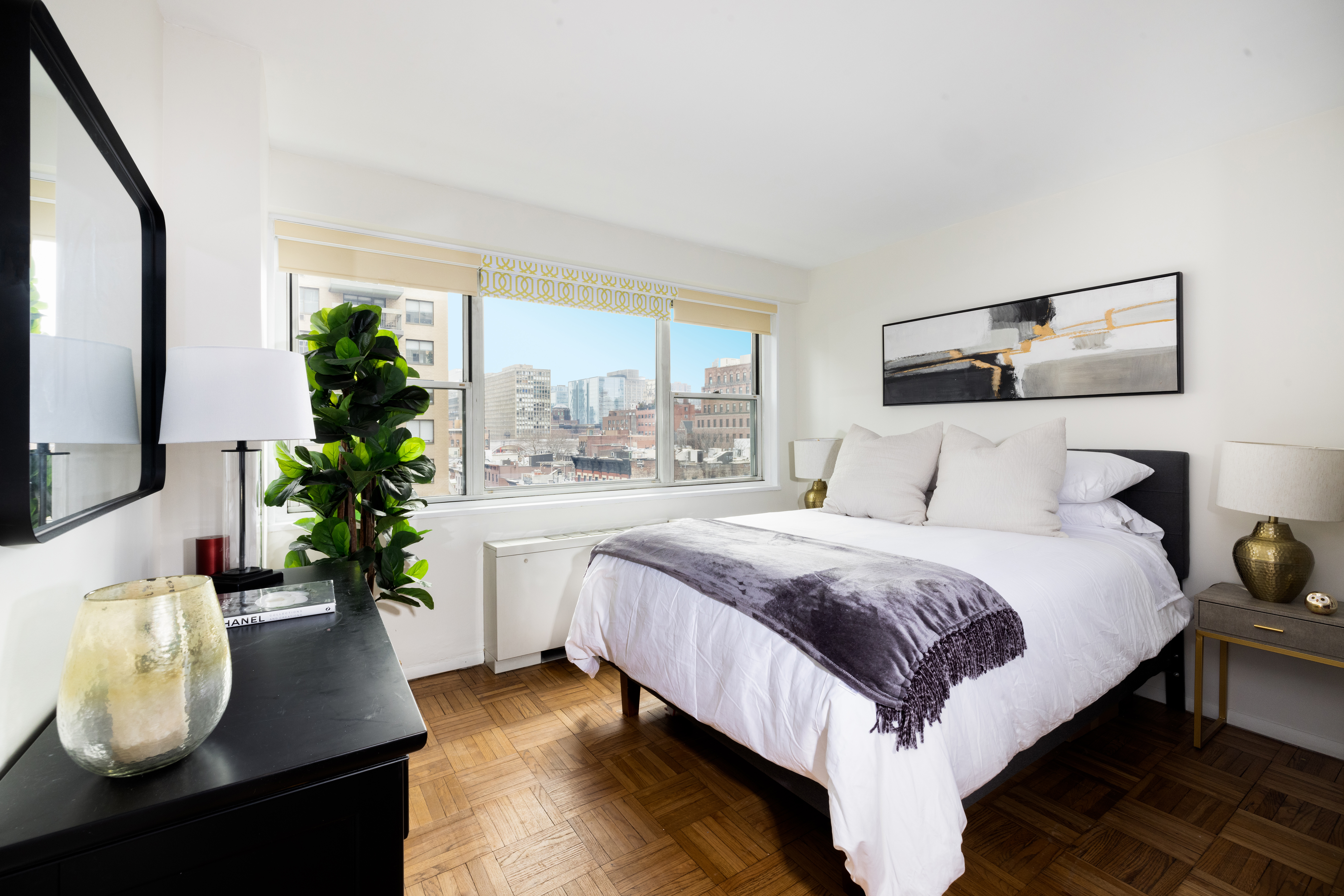165 East 32nd Street, Unit 9D Manhattan, NY 10016 - Photo 3 of 12 a bedroom with a large bed and a potted plant