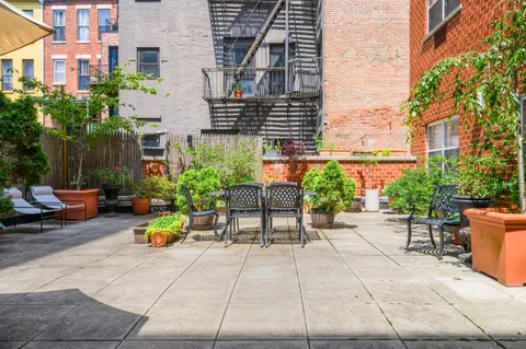 a view of backyard with outdoor seating and plants