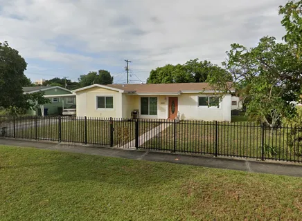 a view of a house with backyard and fence