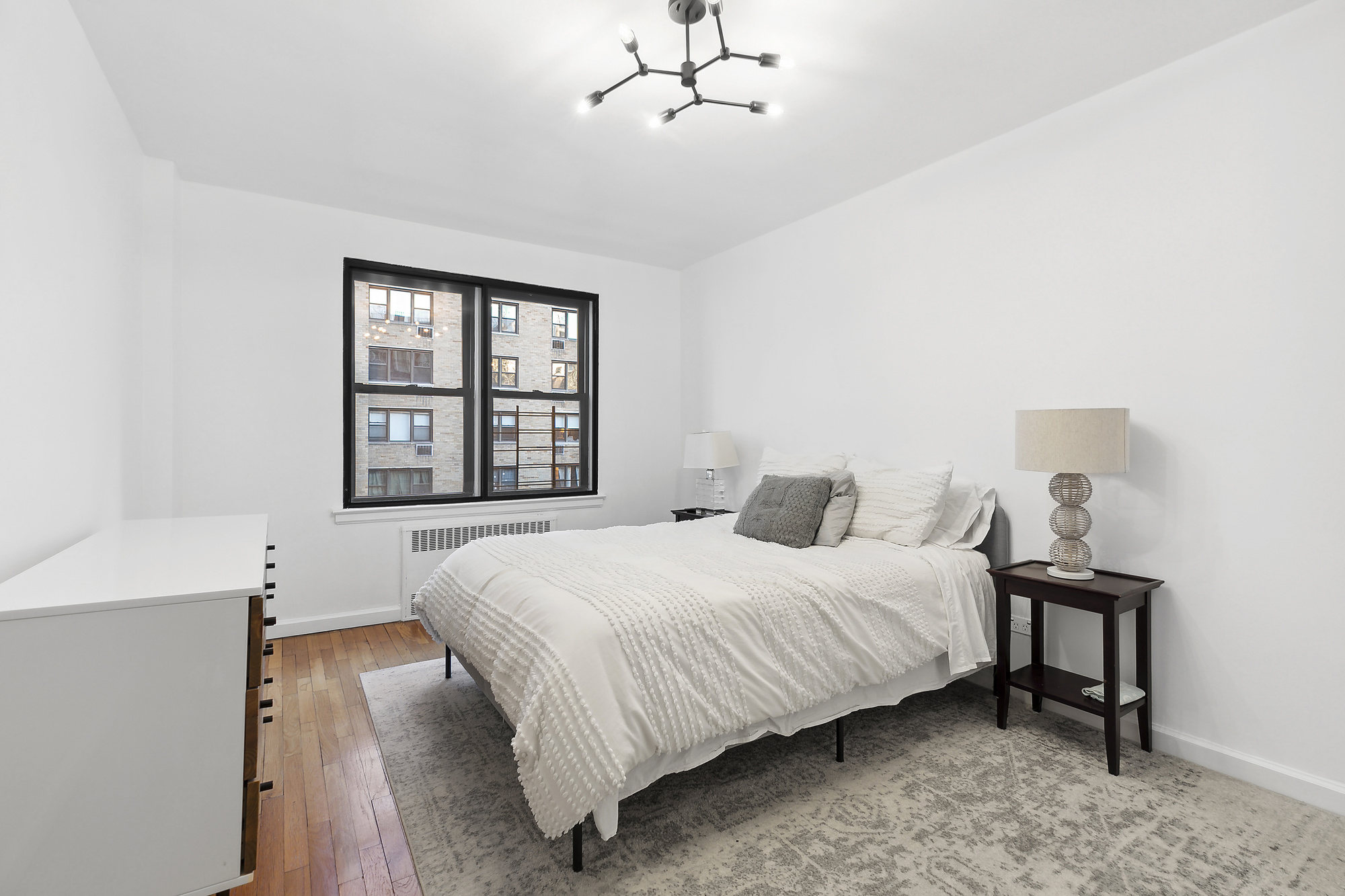 157 East 18th Street, Unit 4H Manhattan, NY 10003 - Photo 4 of 7 a bedroom with a bed table and window