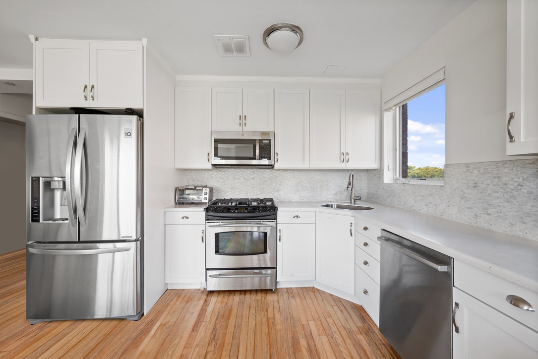 702 Ocean Parkway, Unit 5A Brooklyn, NY 11230 - Photo 7 of 9 a kitchen with cabinets stainless steel appliances a sink and a window