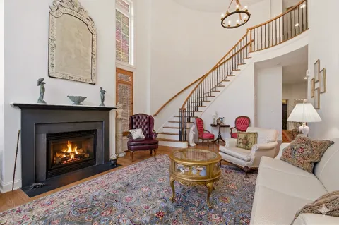 a living room with furniture a fireplace and a large window