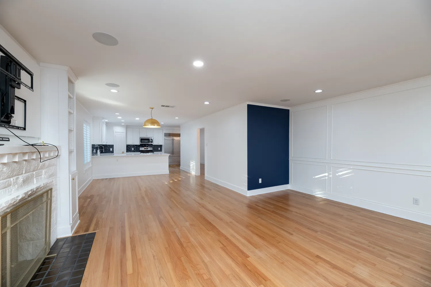 a view of kitchen with kitchen island wooden floors appliances and cabinets