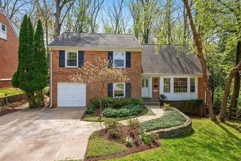 a front view of a house with a yard and a garden