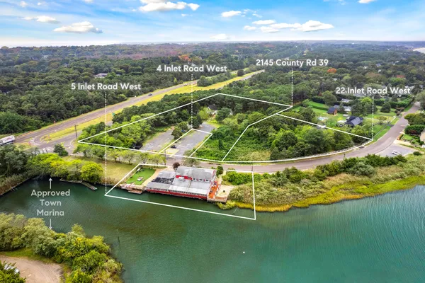 an aerial view of residential houses with outdoor space and lake view