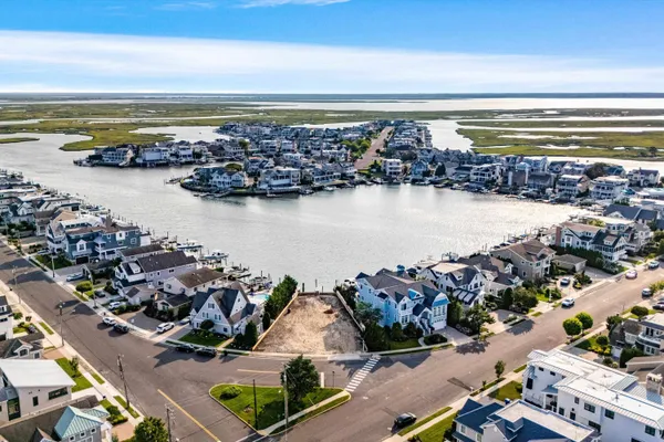 an aerial view of ocean and residential houses with outdoor space
