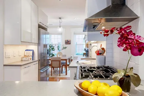 a kitchen with stainless steel appliances granite countertop a stove a sink and a dining table