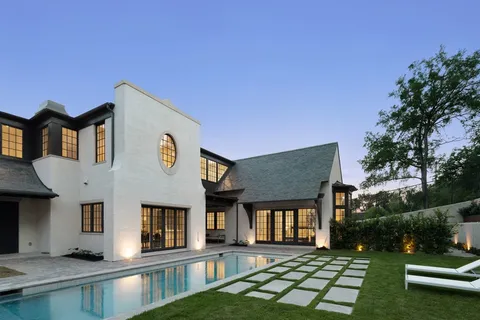 a view of a house with backyard and sitting area