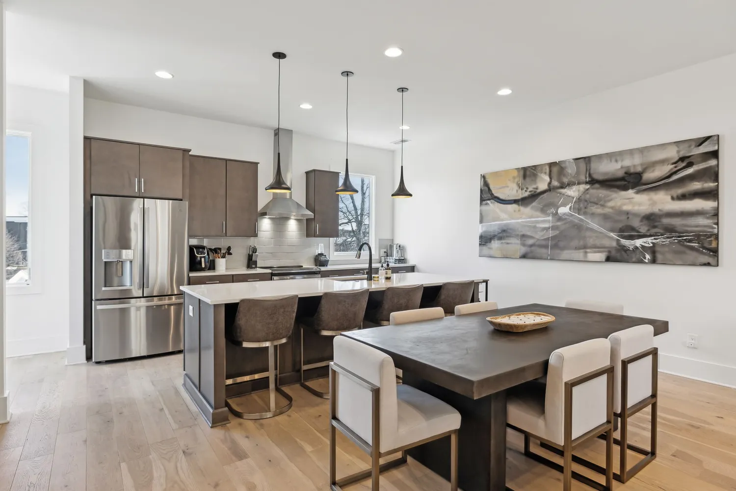 a kitchen with stainless steel appliances granite countertop a kitchen island a table and chairs in it