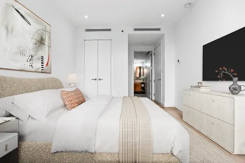 a bedroom with a bed and a flat screen tv