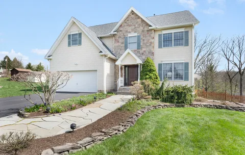 a front view of a house with a garden and plants