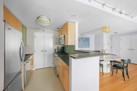 a kitchen with stainless steel appliances granite countertop a sink a stove and a refrigerator