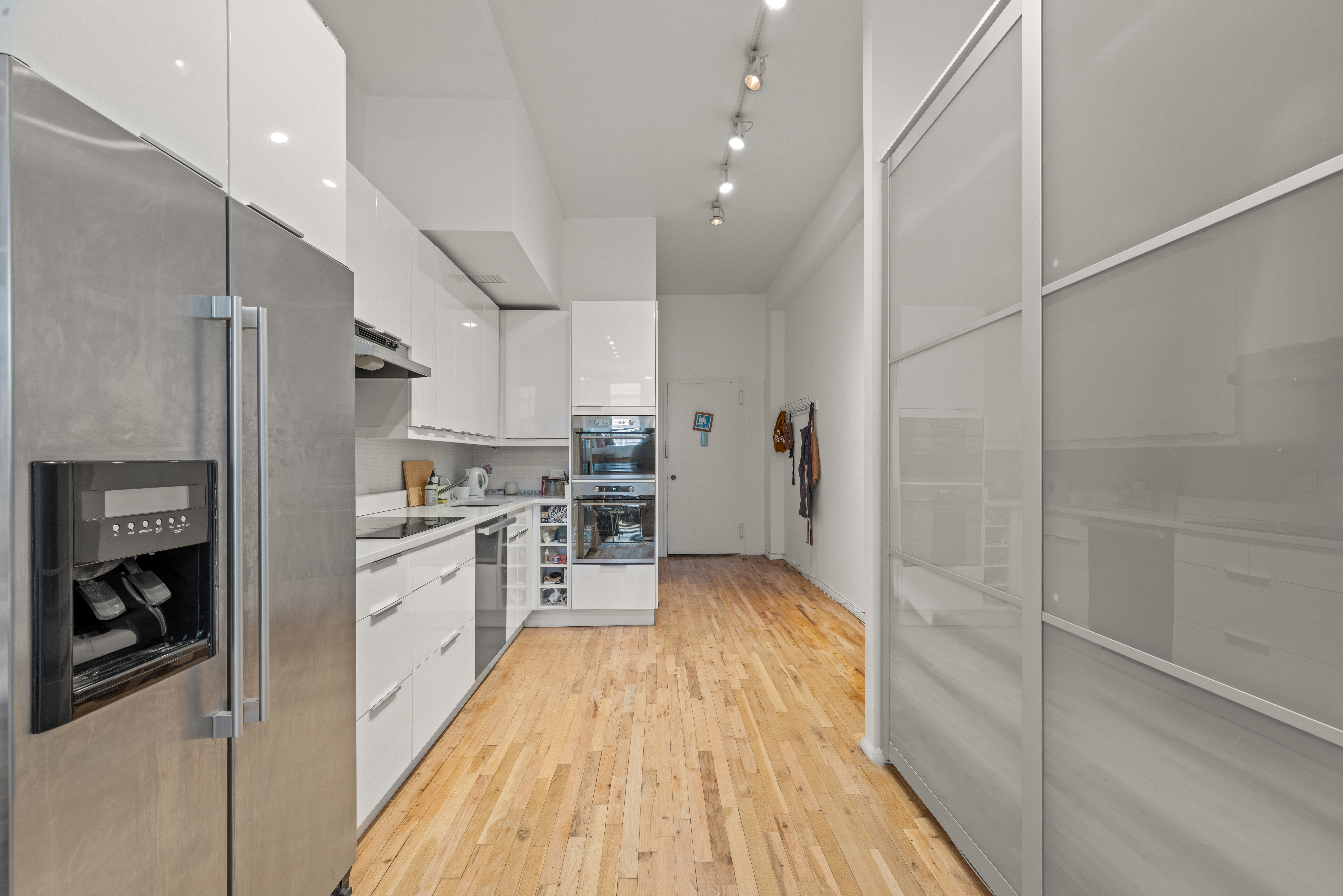 a kitchen with white cabinets and stainless steel appliances