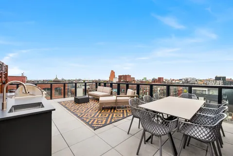 a view of a roof deck with furniture