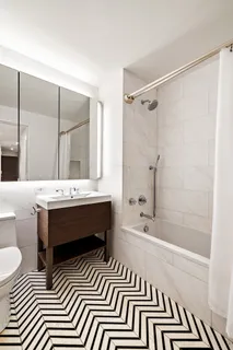a bathroom with a sink a toilet a mirror and shower