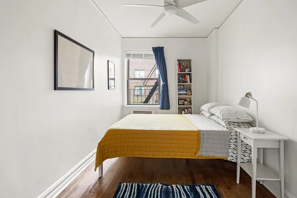 a bedroom with a bed and a large window