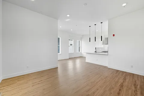 a large white kitchen with kitchen island a sink stainless steel appliances and cabinets