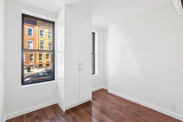 an empty room with wooden floor and a window