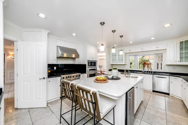 a kitchen with a stove a refrigerator and a dining table