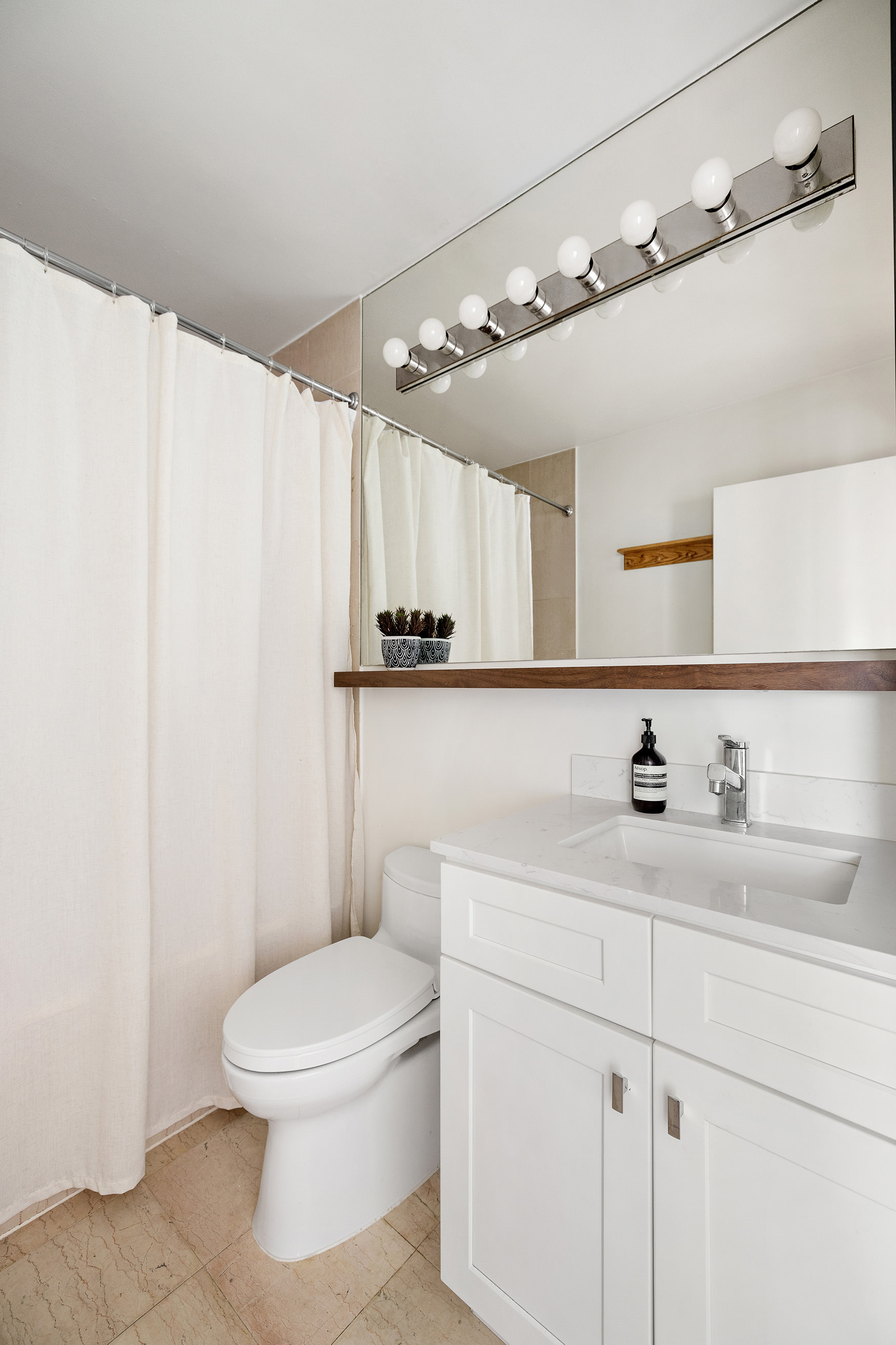 455 East 86th Street, Unit 11A Manhattan, NY 10028 - Photo 10 of 11 a bathroom with a toilet sink a mirror and vanity